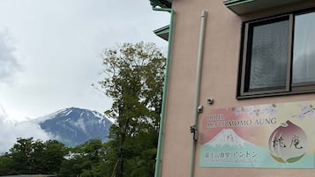 Un bâtiment sur lequel on peut lire les enseignes « Hôtel Mont Fuji Momoko Aung » et « Restaurant Fuji San Aung Tun », avec une montagne en arrière-plan.