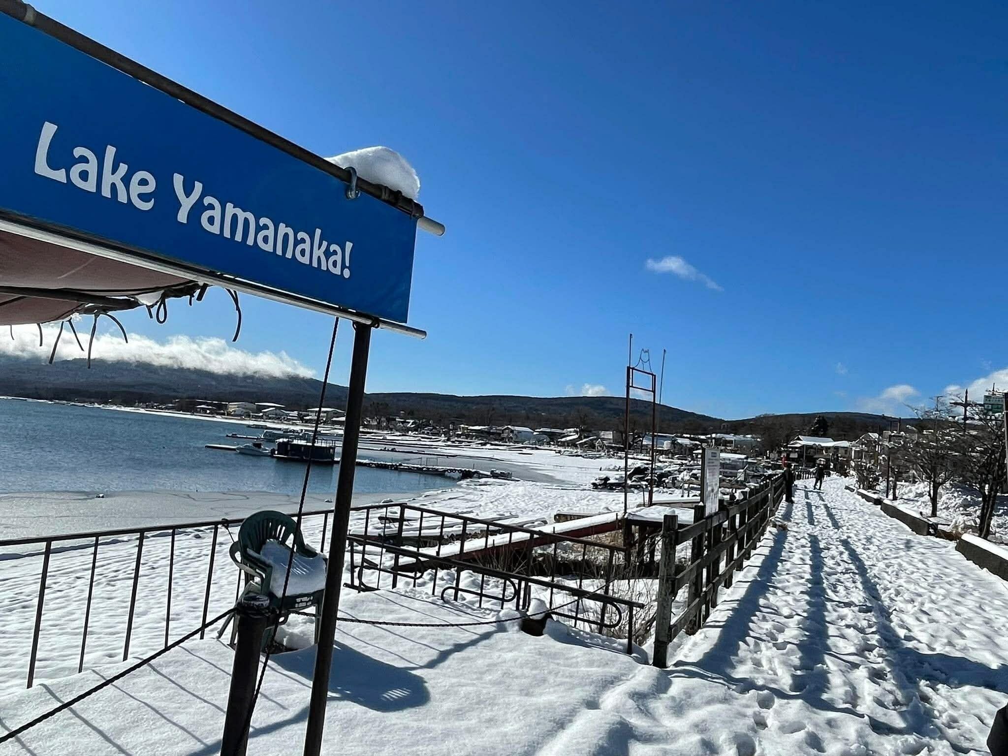 A snowy waterfront with a sign reading 'Lake Yamanakajima!'