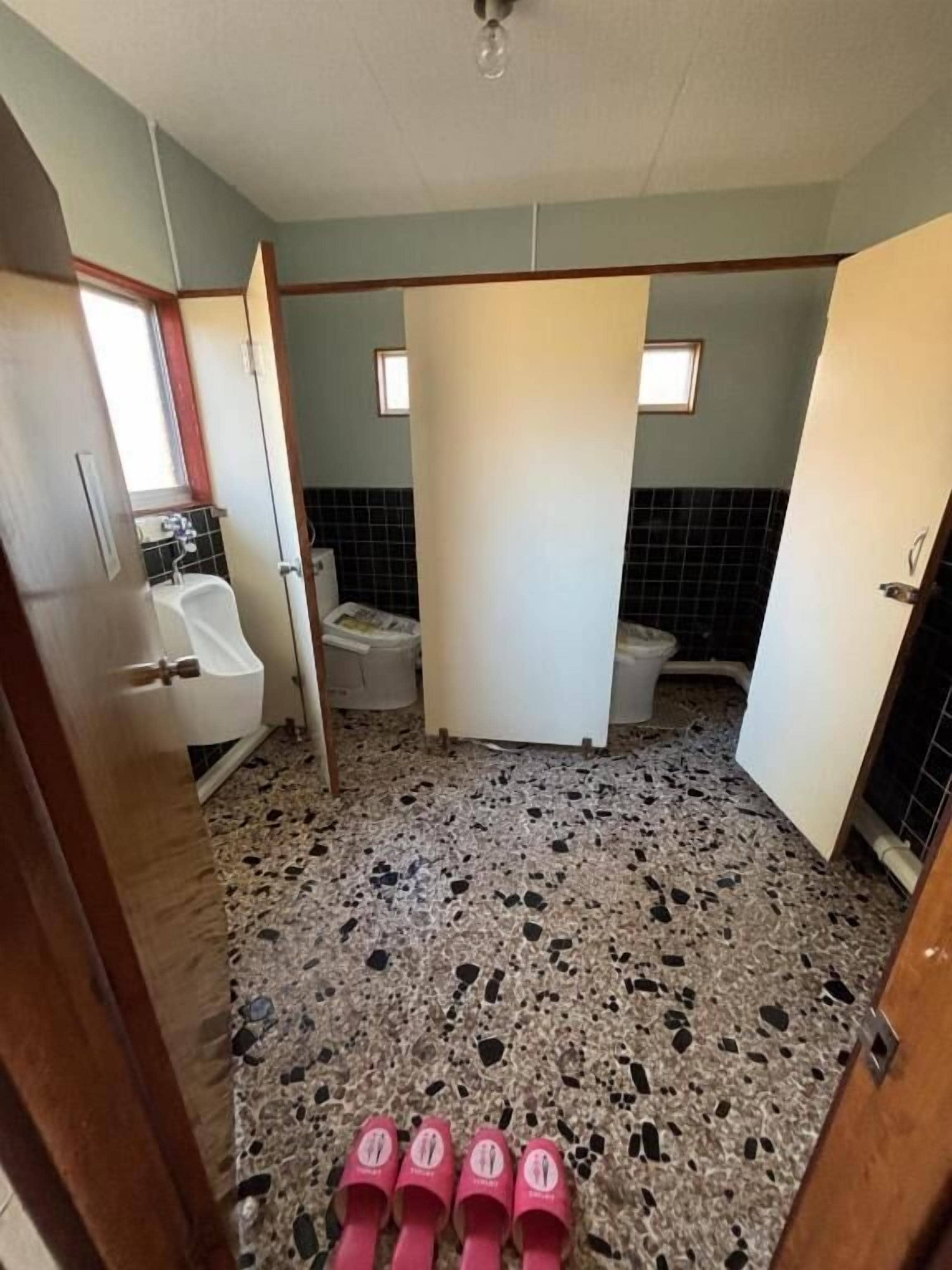 Une salle de bain comprenant un lavabo, des toilettes et un espace douche.