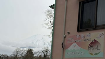 A building with a sign for Hotel Mt. Fuji Mo Aung, featuring a mountain view.