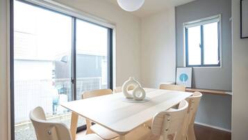 A dining area with a table, chairs, and a vase centerpiece.