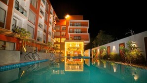 A hotel with a swimming pool, a well-lit entrance, and a reflection in the water. - Abhyagama Hotel (Digha)