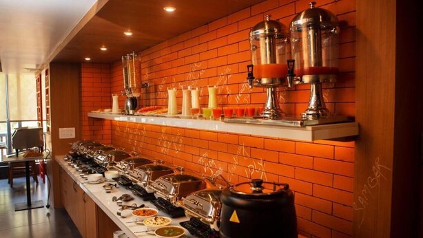 A buffet setup with various food containers and dispensers on a counter. - Abhyagama Hotel (Digha)