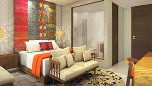 A modern bedroom with a bed, sofa, and a glass shower area. - Abhyagama Hotel (Digha)