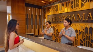 A reception desk with a wooden panel wall and the name 'ABHIYAGAMA' in gold letters. - Abhyagama Hotel (Digha)