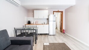 Um espaço compacto com cozinha compacta, área de refeições e sofá.