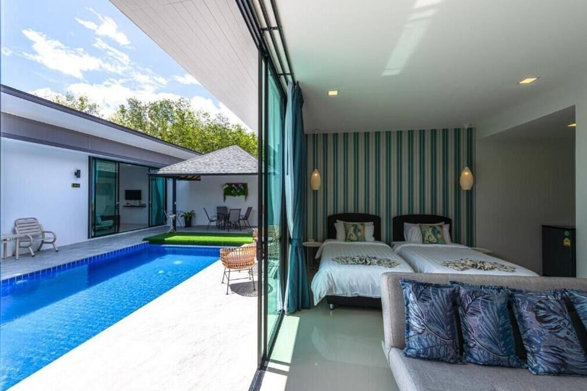 Habitación de hotel moderna con un ventanal grande, una cama, un sofá y una piscina.