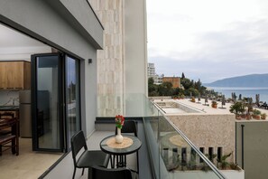 Ein Balkon mit Esstisch, Stühlen und einem Blumenstrauß.