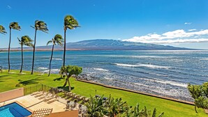 A poolside area with a view of the ocean and mountains. - Celebrate Honeymoon, Anniversary or Birthday...Panoramic Ocean View! (Wailuku)