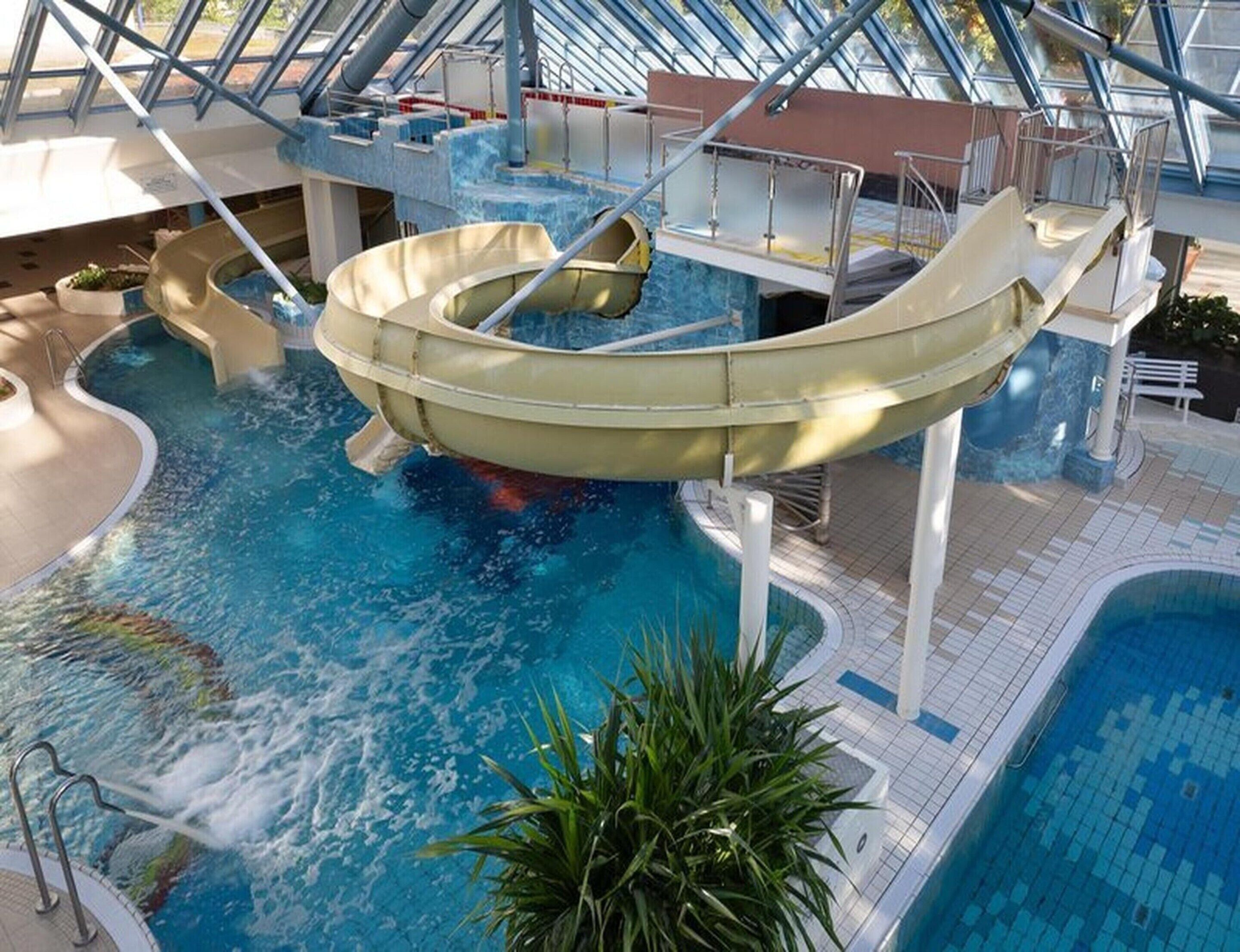 A water park with a large wave pool, slides, and a covered area with seating.