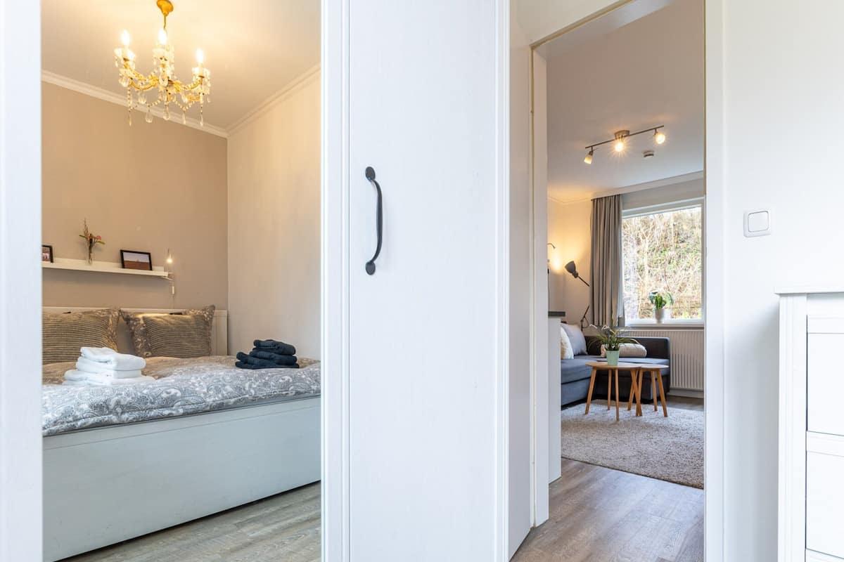 Ein modernes Schlafzimmer mit Bett, Nachttisch und einer Pendelleuchte.