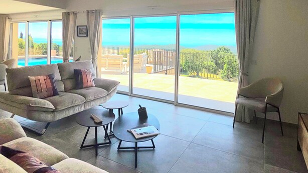 A spacious living area with a large window, a sofa, a coffee table, and a chair. - Villa with pool, sea view, Corse-du-Sud (Monacia-d'Aullène)