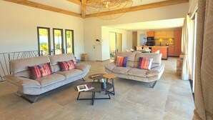 A spacious living area with two sofas, a coffee table, and a dining area in the background. - Villa with pool, sea view, Corse-du-Sud (Monacia-d'Aullène)