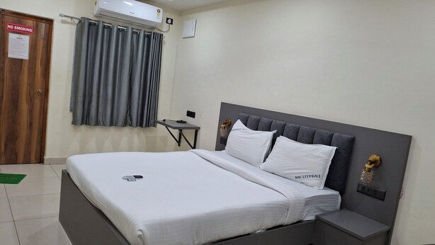 Camera d'albergo con un letto, un comodino e un condizionatore d'aria a parete.