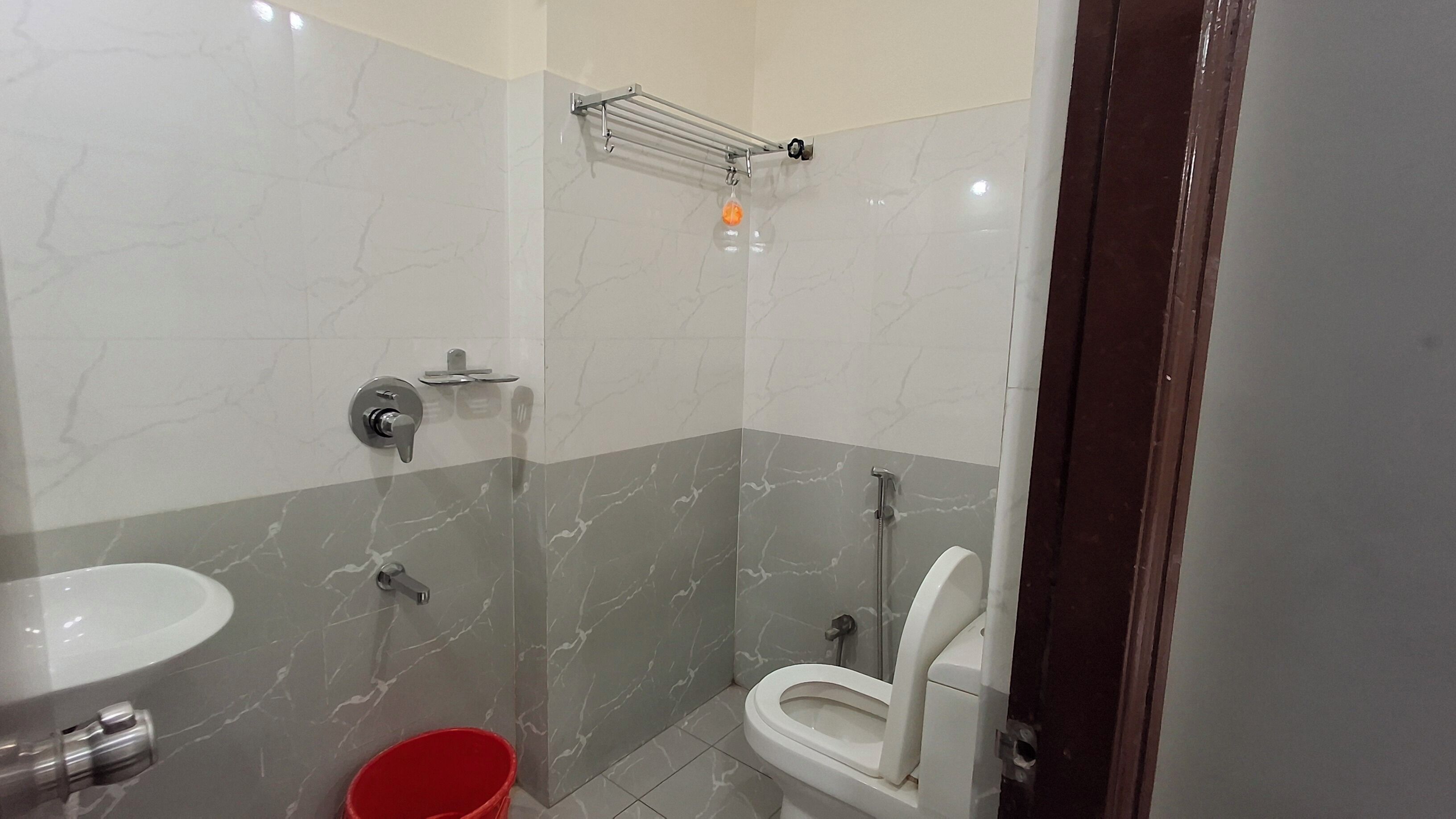 Un baño con inodoro, lavabo y zona de ducha.