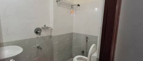 Un baño con inodoro, lavabo y zona de ducha.