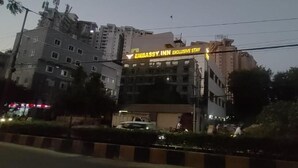 Un edificio a più piani con un cartello che recita 'EMBASSY INN EXCLUSIVE STAY'.