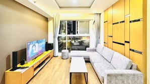 A living room with a sofa, coffee table, TV, and wooden cabinets. - Sunflower Home - Scenic Valley 2 (Ho Chi Minh City)