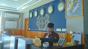 Una recepción con relojes, una foto familiar enmarco y un emblema decorativo en la pared.