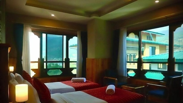 Una habitación de hotel con dos camas, una ventana con vistas, un escritorio y una silla.