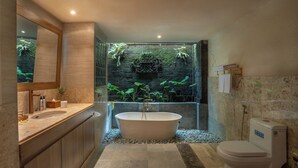 Une salle de bain moderne avec une baignoire sur pieds, des toilettes, un lavabo et un grand miroir.