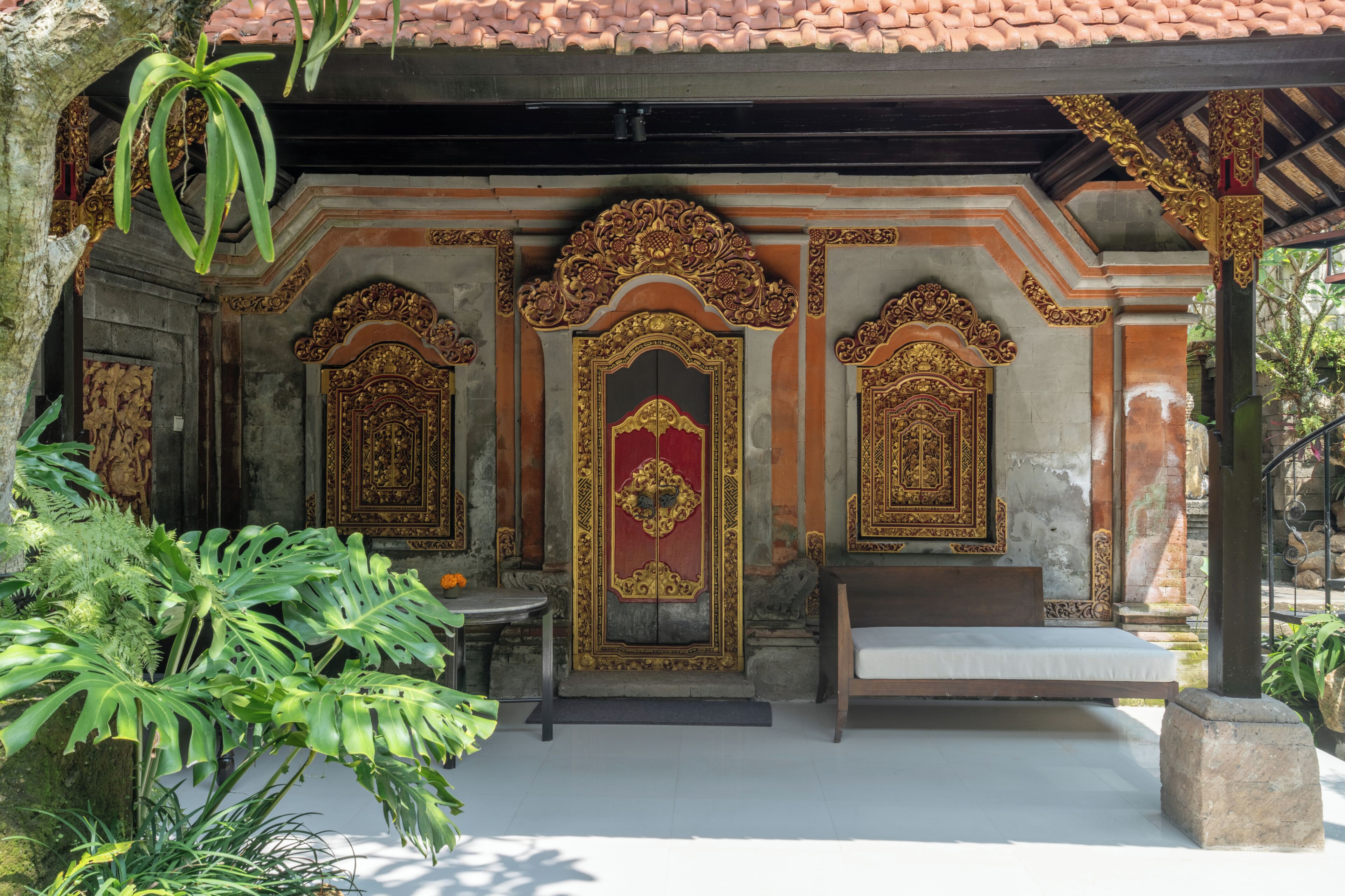 A traditional building with ornate doors and a bench outside.