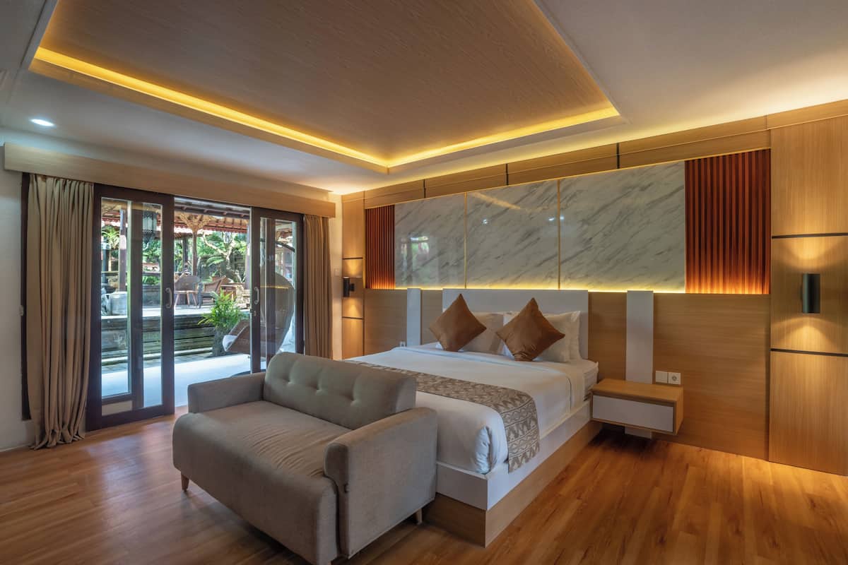 Quarto moderno com uma cama grande, um sofá, uma parede de mármore e uma porta de vidro deslizante.