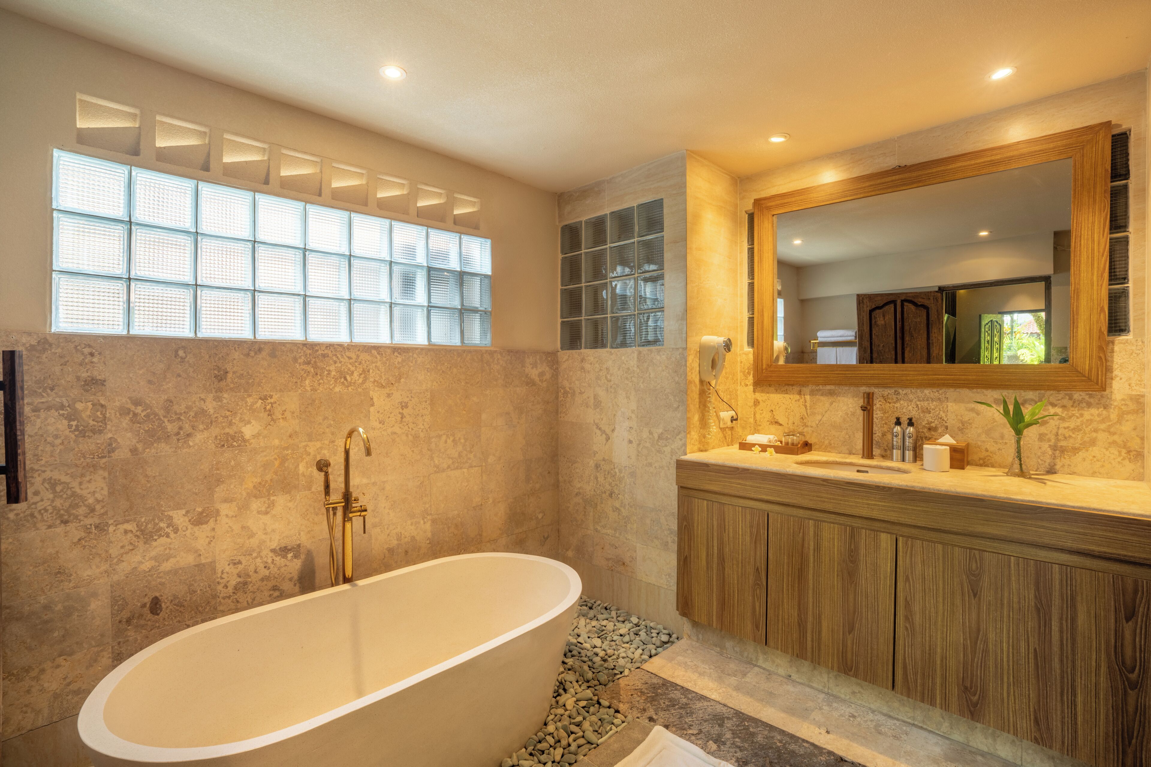 A modern bathroom with a freestanding bathtub, a wooden vanity, and a large mirror.