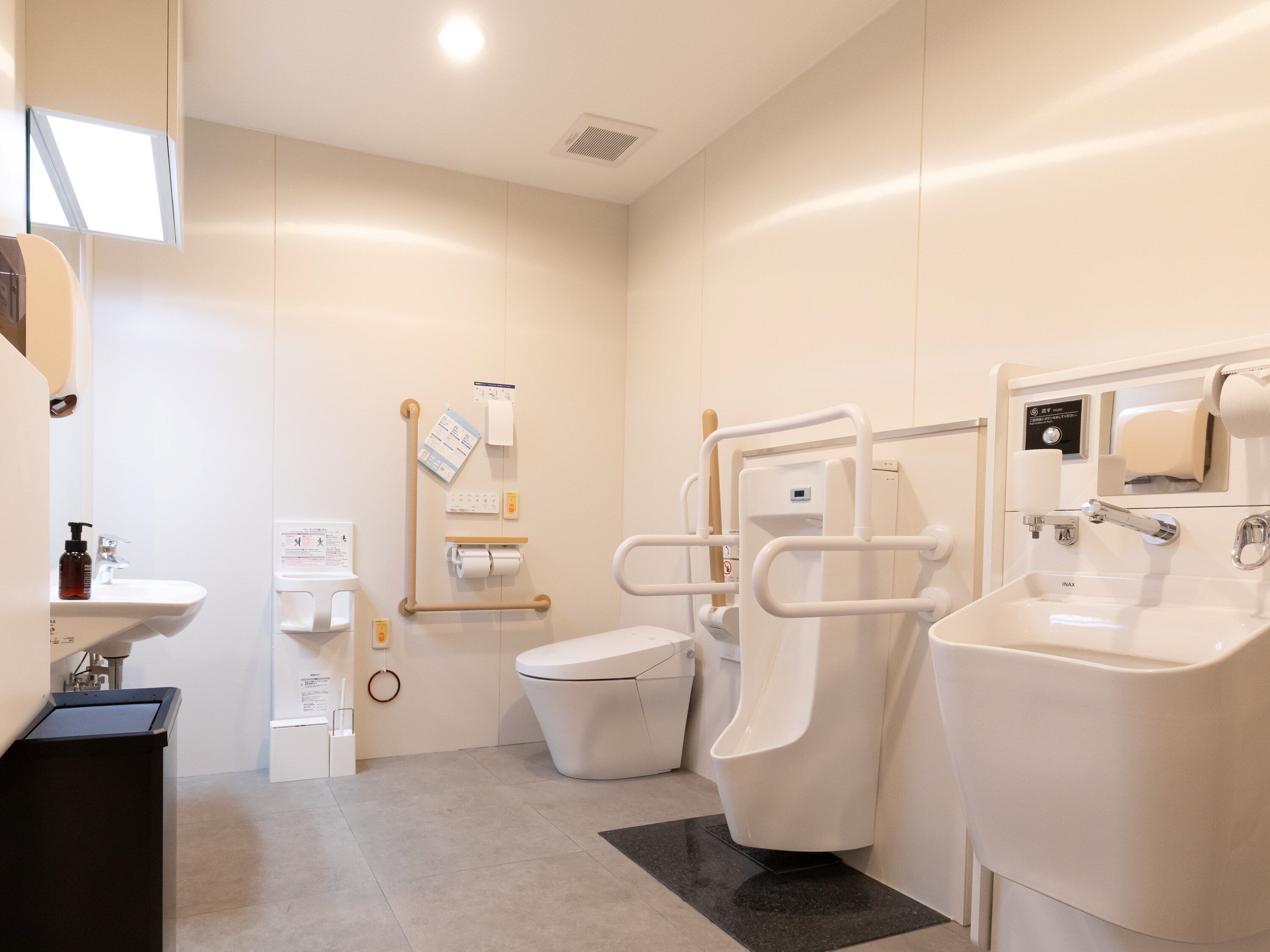 Une salle de bain moderne équipée de toilettes, d’un bidet, d’un lavabo et d’un sèche-mains.