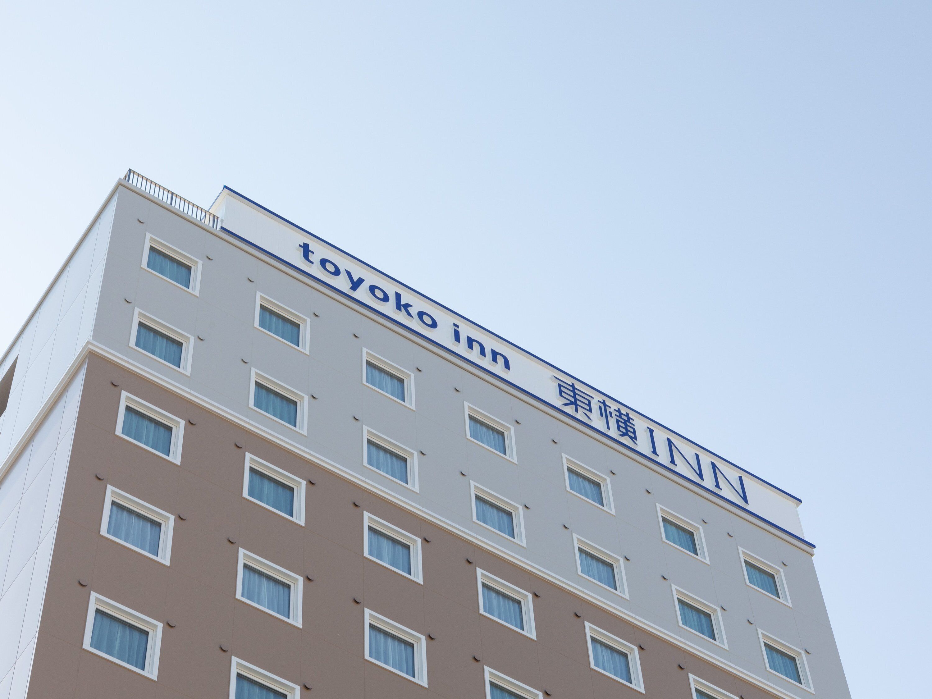 A multi-story building with a sign reading 'toyoko inn'.