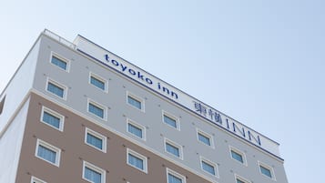 A multi-story building with a sign reading 'toyoko inn'.