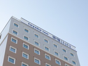 Un immeuble à plusieurs étages sur lequel on peut lire l’inscription « Toyoko Inn ».