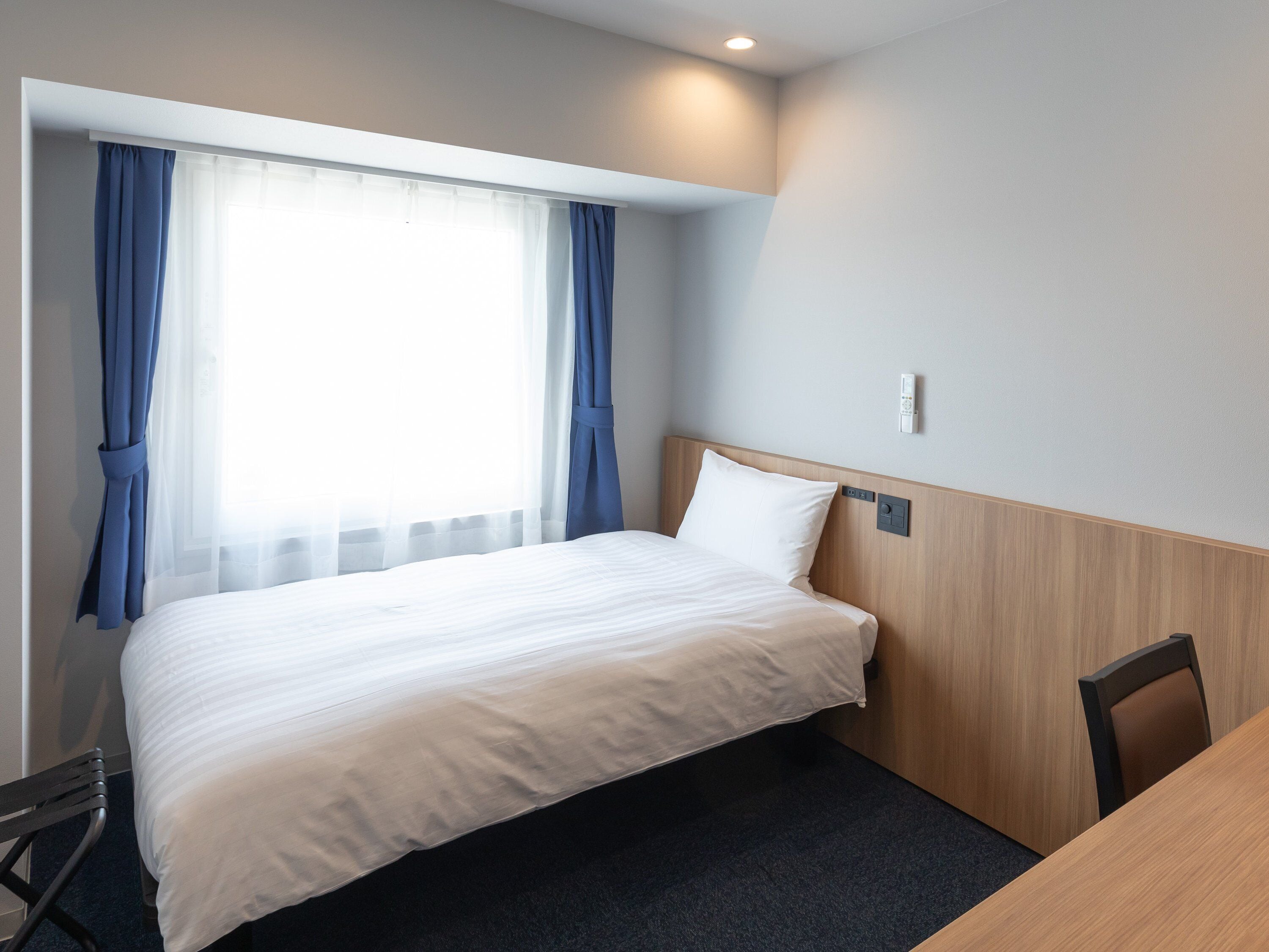 Ein Hotelzimmer mit einem Bett, einem Schreibtisch und einem Stuhl.