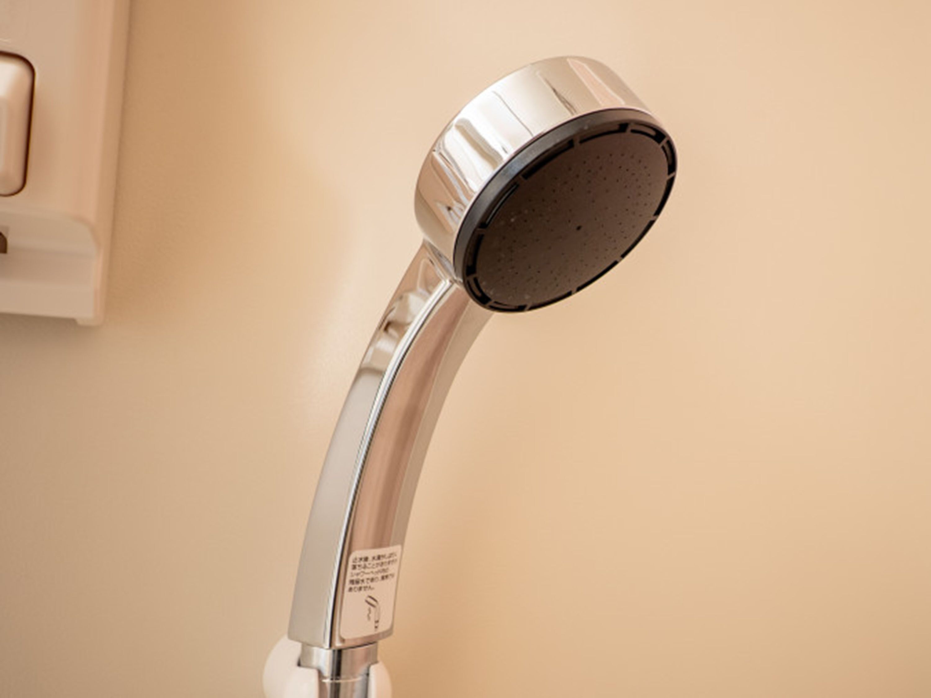 A showerhead with a curved design, a control panel, and a wall-mounted installation.
