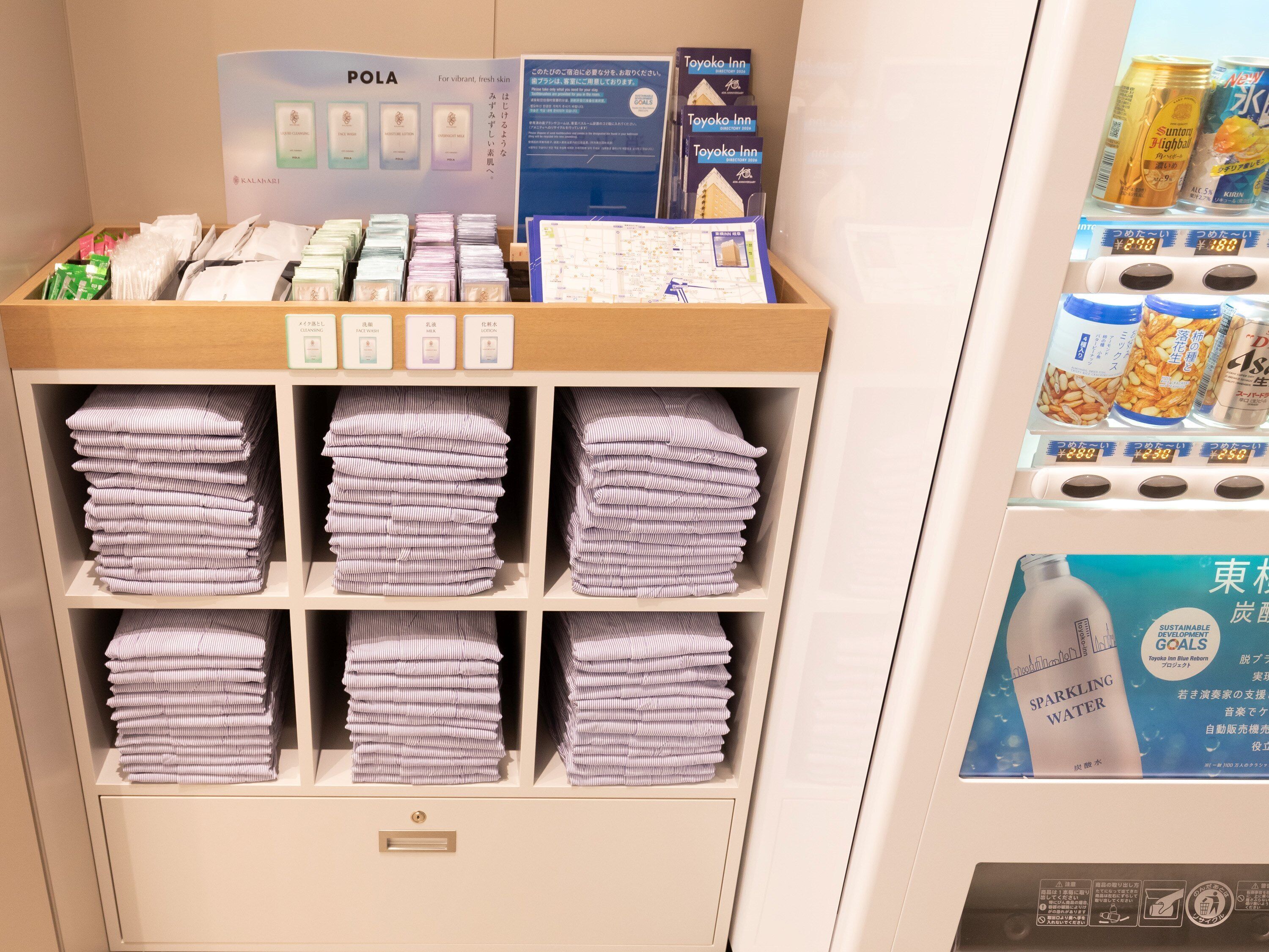 A hotel reception area with a display of toiletries and folded towels.