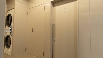 A private elevator with a door marked 'LADIES' and a wall-mounted washer in a hallway.