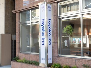 Ein Schild für Toyoko Inn vor einer modernen Gebäudefassade.