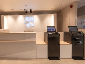 A hotel reception desk with a digital display, a laptop, and a payment terminal. - Toyoko Inn Gifu (Gifu)