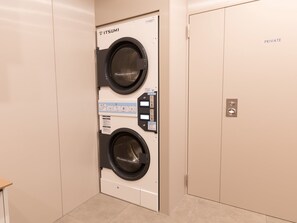 A private laundry room with two washing machines, a control panel, and a door marked 'PRIVATE'. - Toyoko Inn Gifu (Gifu)