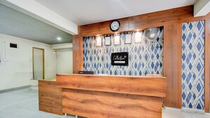 A reception desk with a clock, framed certificates, and a sign indicating it's a company-serviced collection point. - Hotel O Kakatiya Hills Shree Adithya Luxury (Hyderabad)