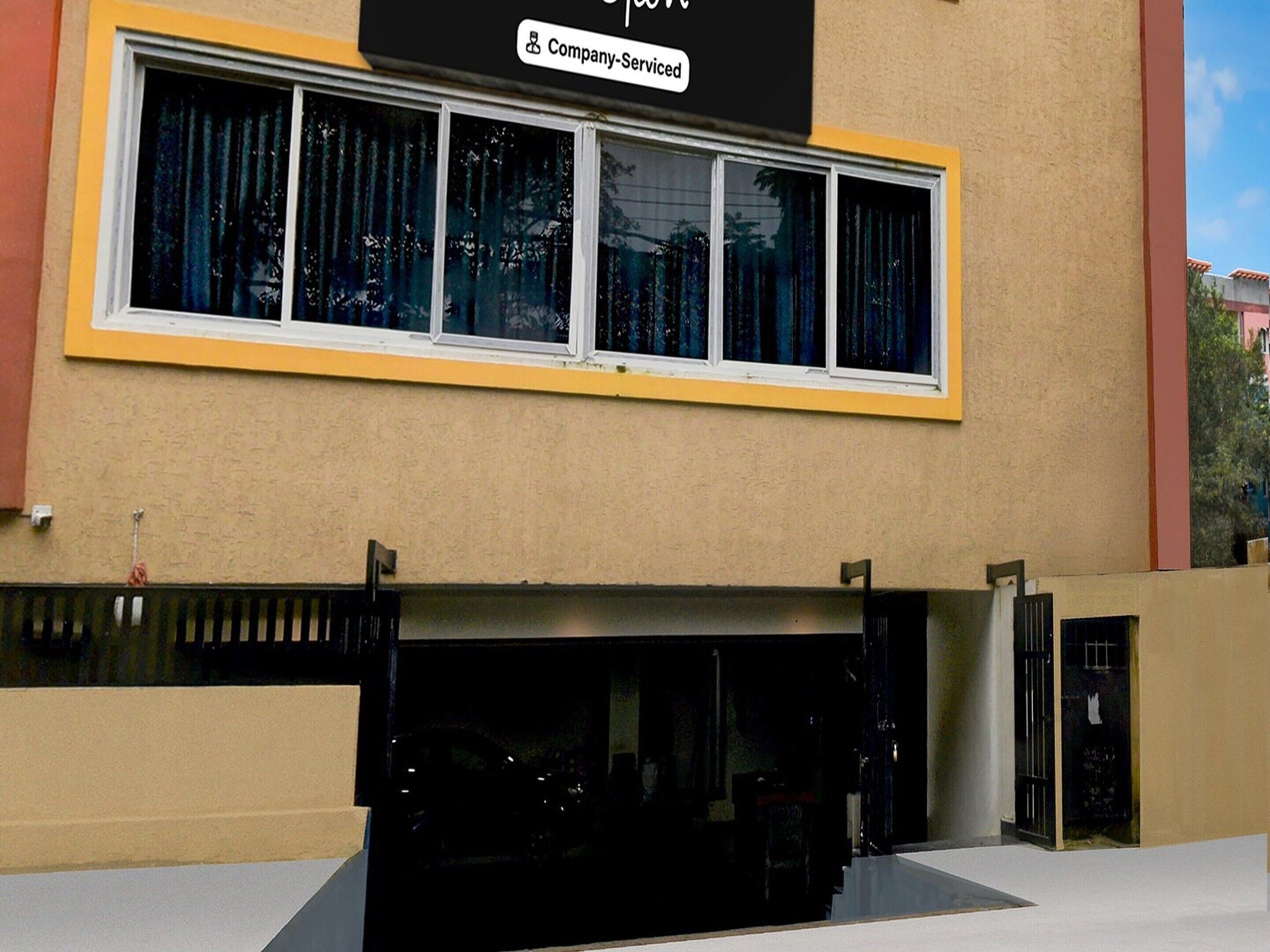 A building with a large window and a sign indicating it is company-serviced.
