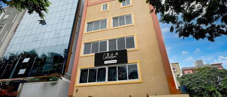 Un edificio de varios pisos con fachada de vidrio moderna y un cartel que indica servicios de empresa.
