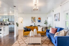 A modern living room with a sofa, coffee table, and artwork on the wall.