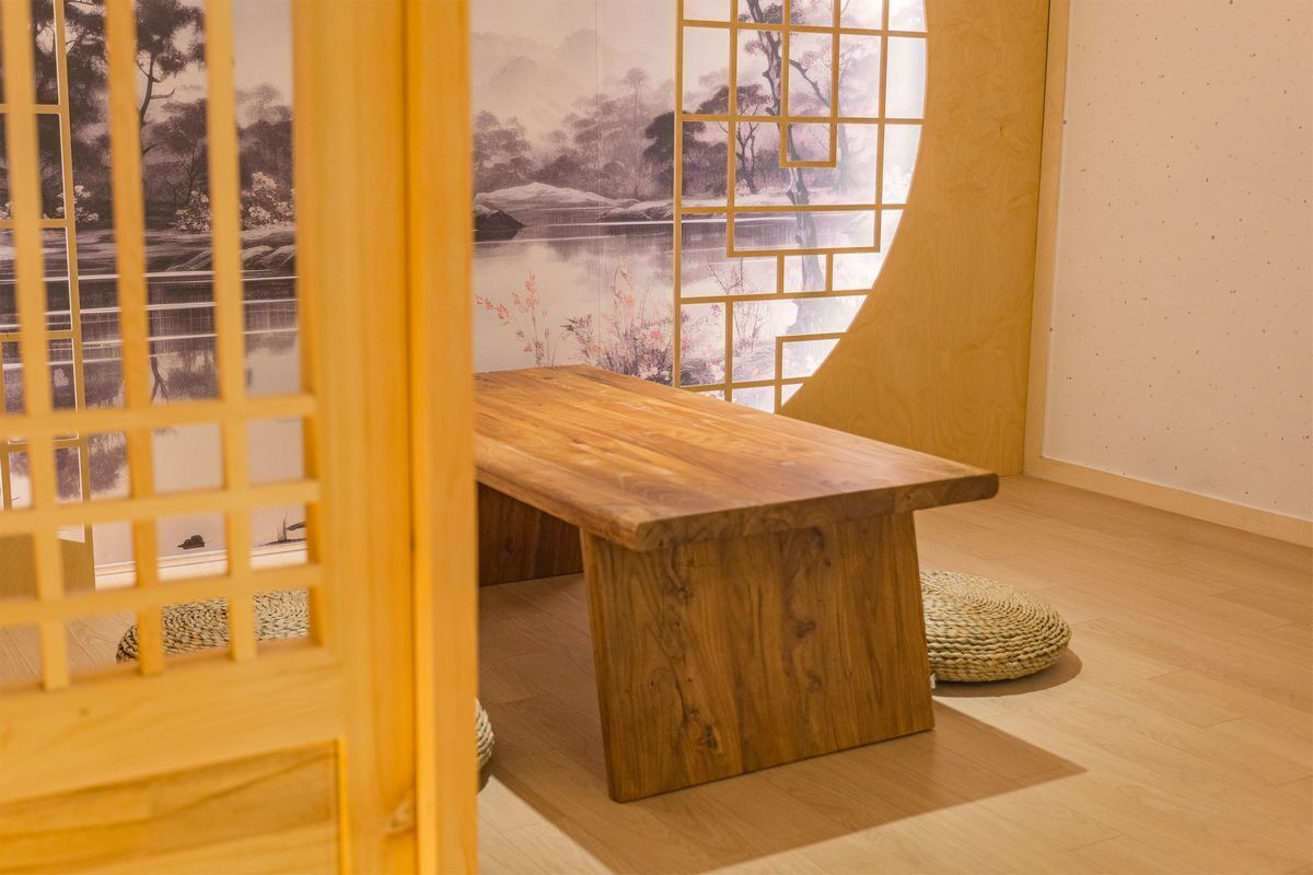 A wooden table in a room with a view of a landscape through a window.