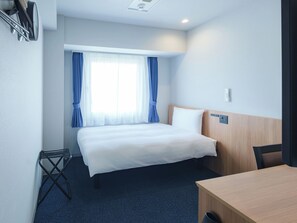 A hotel room with a bed, a desk, a chair, a window with curtains, and a ceiling light. - Toyoko Inn Ube-Shinkawa-eki (Ube)