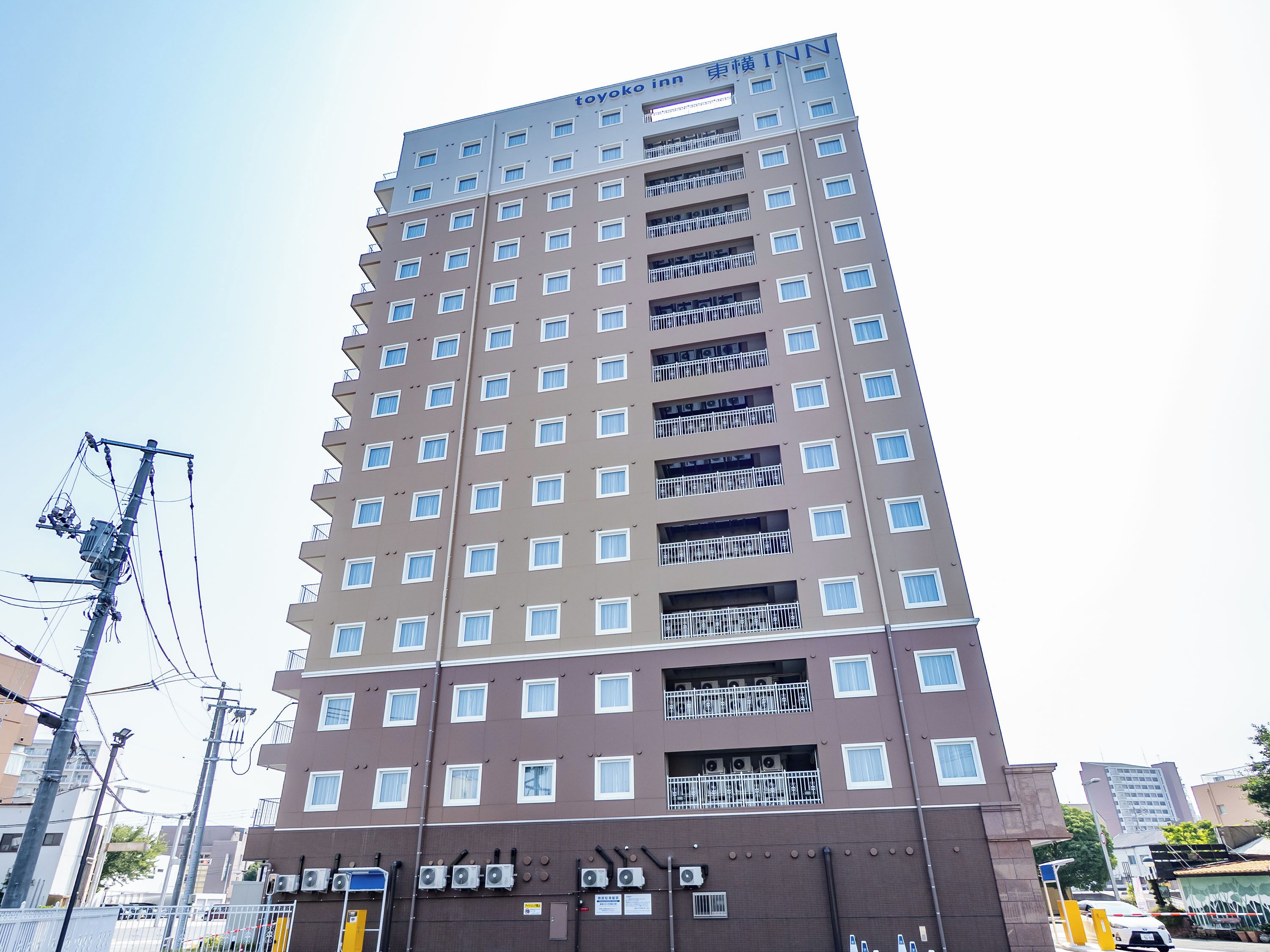 A multi-story hotel with a modern design, featuring balconies on each floor and a prominent signage at the top.