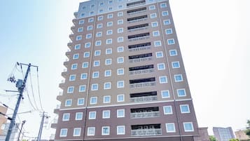 A multi-story hotel with a modern design, featuring balconies on each floor and a prominent signage at the top.