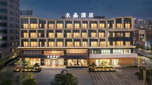 A hotel with a modern facade, multiple floors, and a well-lit entrance. - Crystal Orange Dongguan Huangjiang (Dongguan)