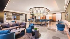 A modern lobby with a central chandelier, seating areas, and a bar. - Crystal Orange Dongguan Huangjiang (Dongguan)