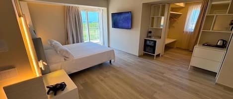Una habitación de hotel moderna con una cama, televisor, escritorio y armario.